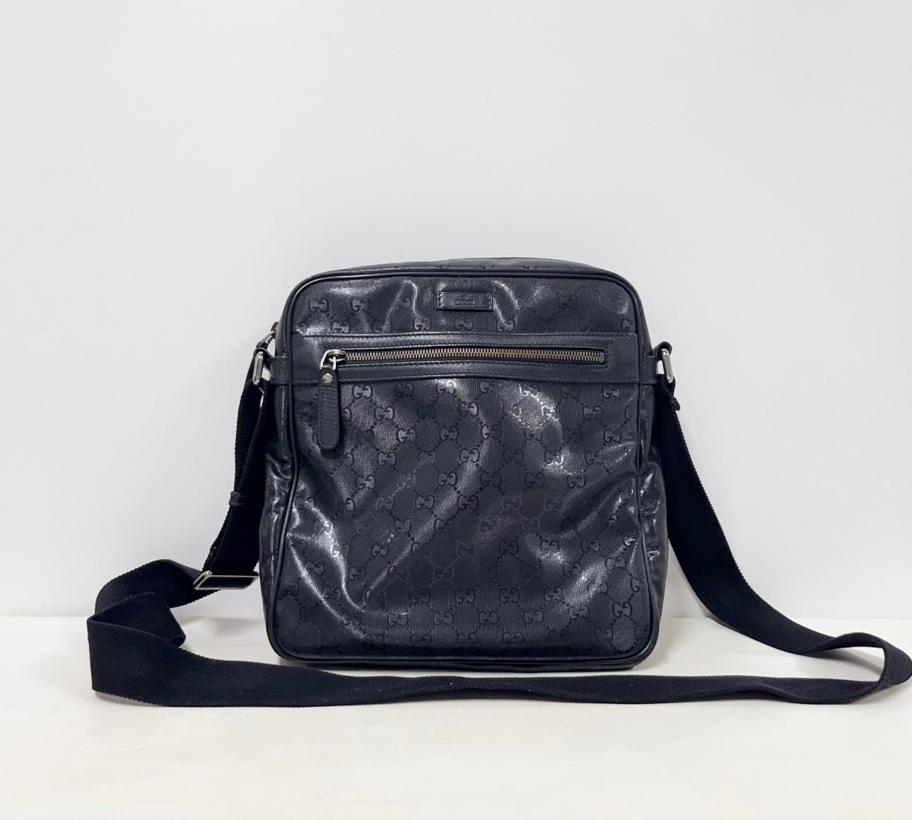 Gucci GG Imprime messenger bag in black, featuring a coated canvas body with tonal monogram detailing and adjustable strap